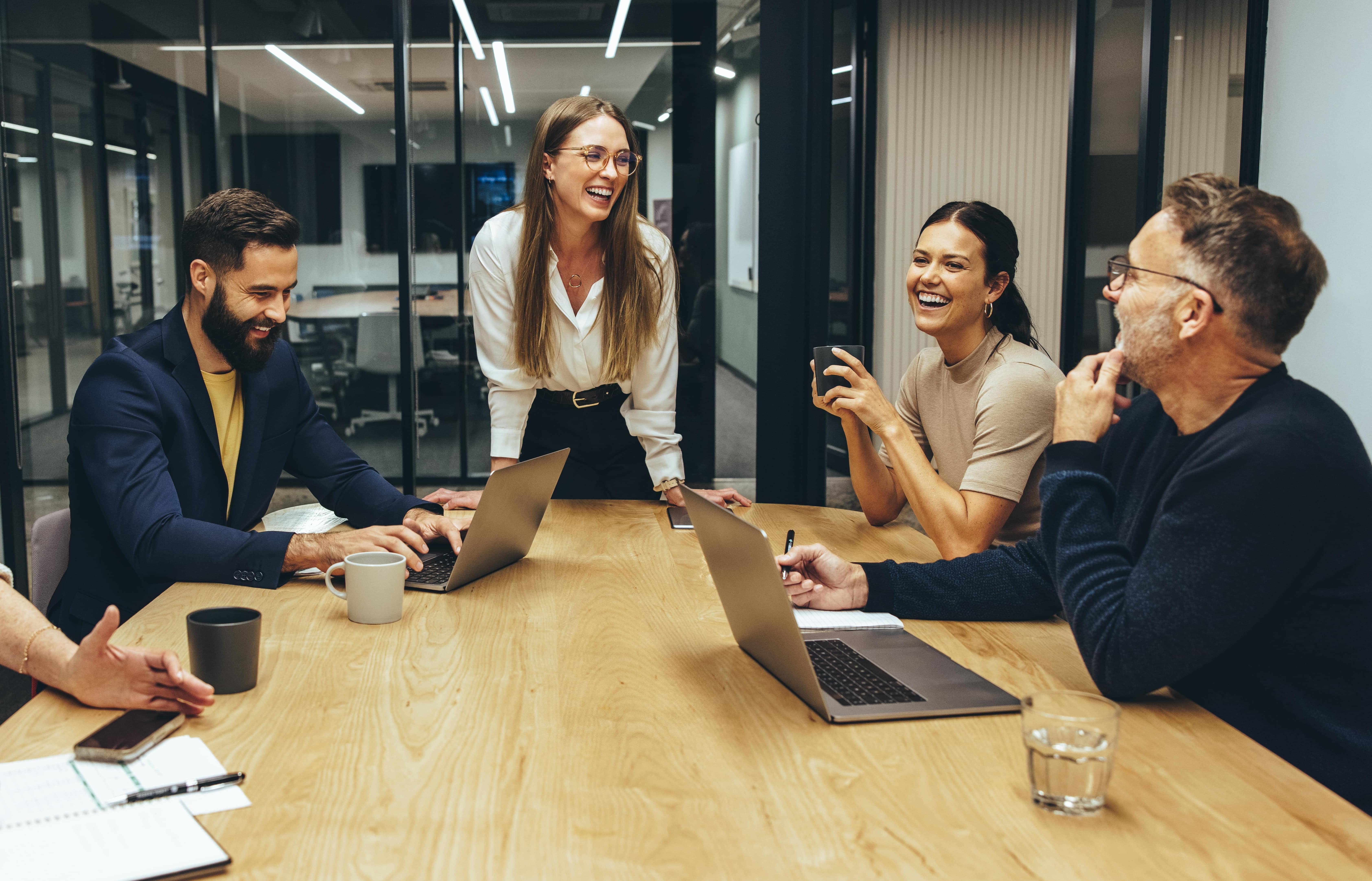 Büro glückliche Mitarbeitende arbeiten Laptop
